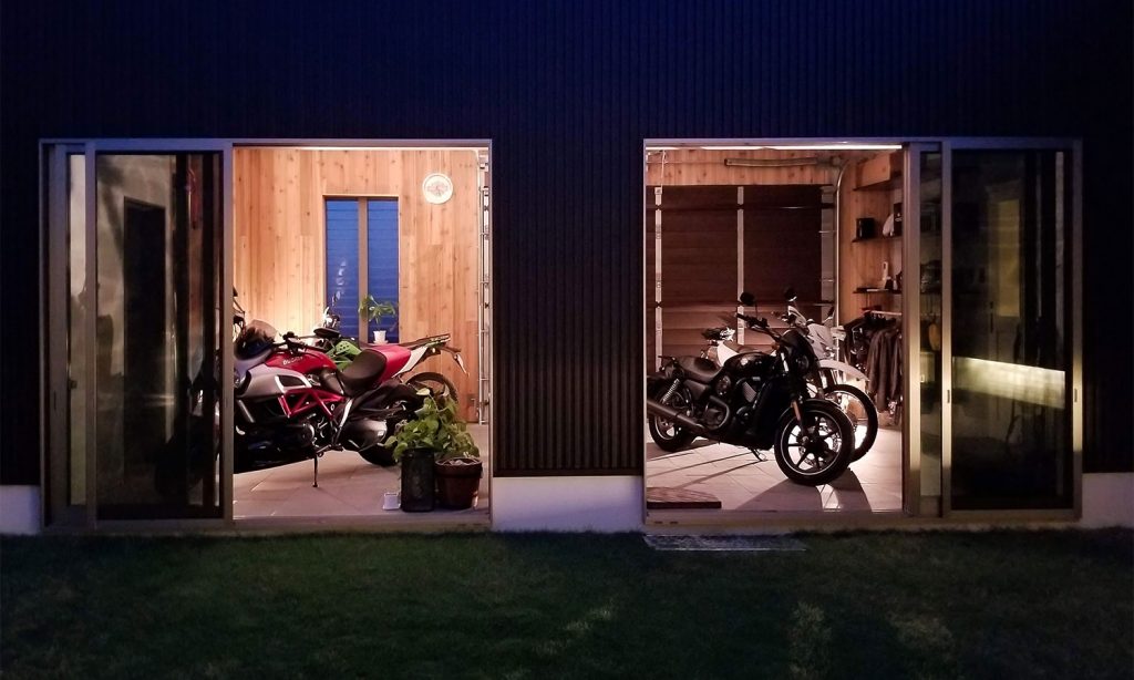 リビングから中庭越しにバイクを眺める平屋 写真